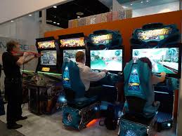 A diverse group of people enjoying video games together in a lively arcade setting.
