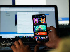 A man in India watches a YouTube video on his smartphone, focused on the screen.