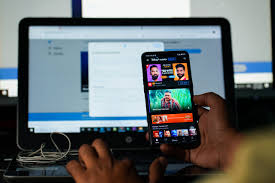 A man in India watches a YouTube video on his smartphone, focused on the screen.