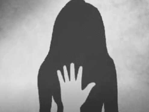 A shadowy silhouette of a person with long hair stands against a grey background. A white hand is raised in front, creating a sense of distance and barrier.