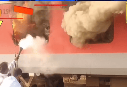 Train on fire with smoke billowing from windows, while two people attempt to extinguish it using a fire extinguisher. Urgent and tense atmosphere.
